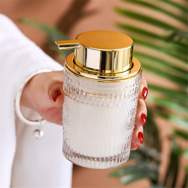 Dispenser sapone in vetro dosatore dorato.