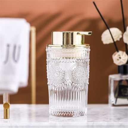 Dispenser sapone in vetro dosatore dorato.