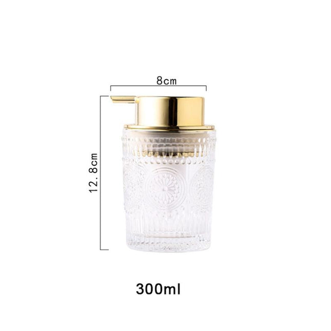 Dispenser sapone in vetro dosatore dorato.